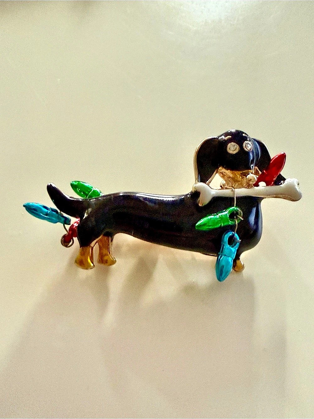Vintage Christmas dachshund brooch featuring a black enameled sausage dog